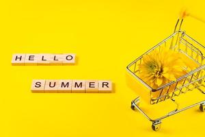 Hello summer. Colorful flowers on yellow background. Vacation and seasonal shopping concept. photo