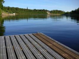 Wooden dock in ivalo clear river at midnight time finland scandinavia photo