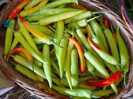 fresh green and red chilli in the rattan basket selling in organic local market thailand photo