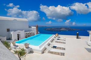 White architecture on Santorini island, Greece. Swimming pool in luxury hotel. Beautiful view, sky over blue sea. Summer vacation and holiday as travel destination concept, amazing tourism background photo