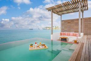 Breakfast in swimming pool, floating breakfast in tropical resort. Table relaxing in calm pool water, healthy breakfast and fruit plate by resort pool. Exotic summer diet. Tropical beach lifestyle photo