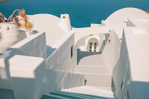 Oia town on Santorini island, Greece. Traditional and famous houses stairs with blue domes over the Caldera, Aegean sea, panorama photo