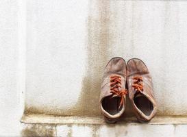 zapatillas viejas en la pared de fondo. foto