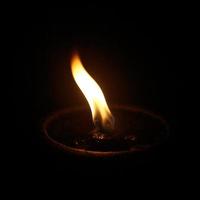 Flame of an oil lamp in the dark photo