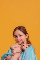 Teen girl in a blue hoodie holds a sphinx cat in her arms. Girl and pet. photo