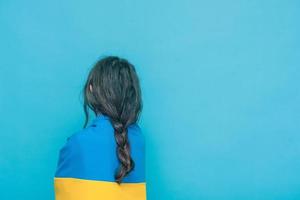 Yellow with blue fabric on the shoulders. Photo of a girl with a braid on a blue background.