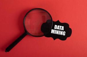 Magnifier and black sticker with Data Mining text on red background