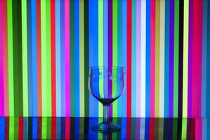 glass goblet on stripes background photo