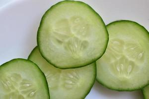 Sliced slices of green cucumber macro photo as background