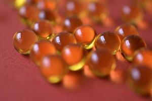 Yellow balls with yellow liquid on a red background. Glass yellow balls. photo