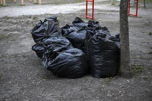 bolsas de basura negras después de la limpieza de calles foto