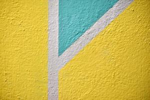 A yellow and blue wall painted with stripes and a triangle photo