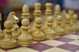 Chessboard with wooden pieces black and white photo