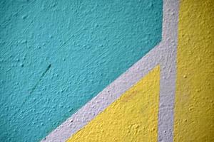 A yellow and blue wall painted with stripes and a triangle photo