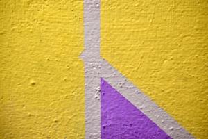 A yellow and blue wall painted with stripes and a triangle photo
