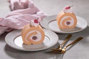 Cherry blossom flavored roll cake or swiss roll with whipped cream and cherry blossoms bean jam photo