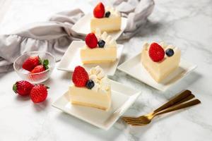 Delicious cheesecake with fresh strawberries and blueberries without baking on marble table