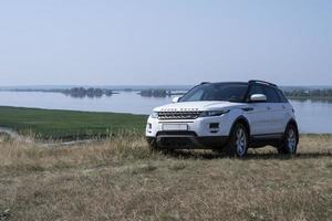 el coche range rover evoque se alza sobre una colina con el telón de fondo del río kama en la república de tatarstán. un día claro y soleado el 19 de agosto de 2021 foto