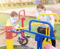 Parents take students in school uniforms for family activities. Play on the playground equipment Rides with bikes, circles, and fun for two evening after school photo