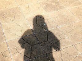 Take a shadow of yourself on the road Shadows against sunlight create a dark shape. showing different surfaces photo