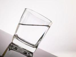 glass for liquor Translucent elements made of glass are placed on a tilted table. empty objects isolated on white background photo