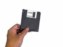 Hand holding a Floppy A disc, insert the reader. to read and write data It's technology old that have been used for a long time has a rectangular shape, white background, has Clipping path photo