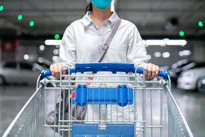 happy woman female with closeup shopping cart or trolley in car parking of fresh maket for healthy housewife in supermarket store photo