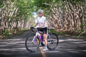 atleta de ciclismo mujer feliz prepararse para andar en bicicleta en la calle, carretera, con alta velocidad para el ejercicio de la afición y la competencia en la gira profesional foto