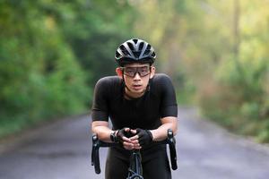 andar en bicicleta cansado y descansar durante el paseo en bicicleta por la calle, la carretera, con alta velocidad para hacer ejercicio y competir en un recorrido profesional foto