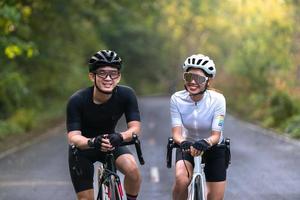 happy couple cycle or ride bicycle on rode in countryside for health life style