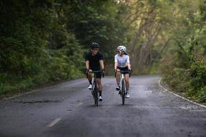 happy couple cycle or ride bicycle on rode in countryside for health life style photo