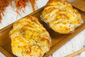 Cheese bread on wooden plate at white wooden table, Close up photo