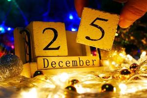 tema del día de navidad con decoración y abeto festivo. calendario de bloque de cubo de madera fecha actual 25 y mes de diciembre. concepto de celebración de navidad y x'mas. foto