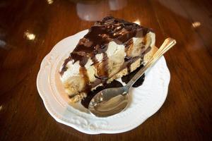 Banana Vanilla Cake with Chocolate in a white dish placed on a wooden background in a cafe.Selective focus photo