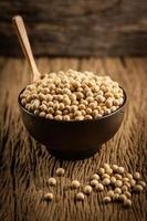 Soybeans in a wooden bowl on a wooden floor Old wood background