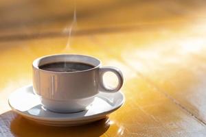 Morning hot coffee on the yellow wooden table On clear day photo