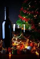 red wine in glass clear,Christmas tree and Ornament on wood table ready for celebrating. photo
