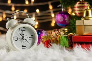 Christmas Retro alarm clock.decoratied with gift box and fir festive on blurred bokeh background.Celebration and Happy New Year Concept. photo