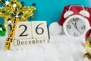 Christmas day theme decoration with hat santa and white retro clock.wood cube block calendar present date 26 and month December.copy space for text.Celebration Christmas and x'mas concept. photo