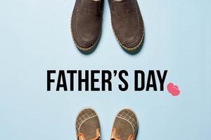 Father's day concept - Father's boots and baby's shoes photo