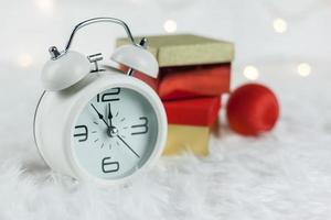 Christmas Retro alarm clock.decoratied with gift box and fir festive on blurred bokeh background.Celebration and Happy New Year Concept. photo
