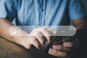 The concept of using technology to search for information, a man's hand is using a smartphone to search for information on social media via the Internet online. photo