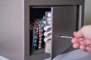 Money and jewelry in an open safe on the table. photo