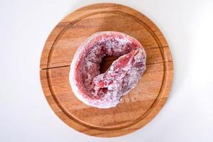 Frozen pork meat on a cutting board. Top view. photo