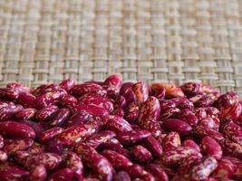 Close-up red beans on bamboo weave as background photo