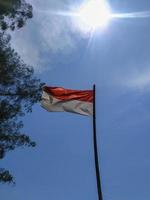 bandera indonesia ondeando en el cielo azul foto