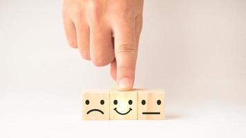 Customer service and Satisfaction concept ,Business people show a feedback with smile face wood cube happy Smiley face icon to give satisfaction in service. rating very impressed. photo