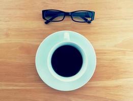 Hot coffee, glasses and notebooks on the table. photo