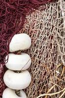 Fishing net white and red with white corks in Santona harbour, Cantabria, Spain. Vertical image. photo