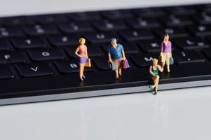 miniature people with shopping bags on a computer keyboard photo